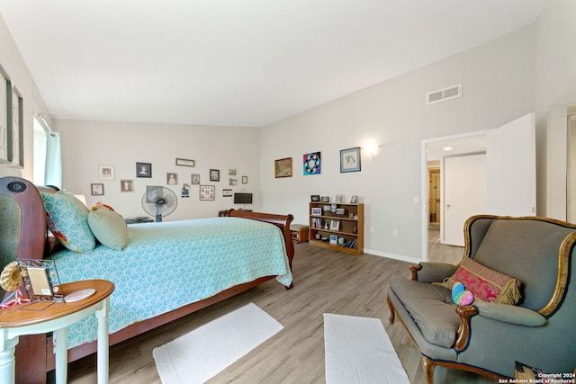 bedroom featuring lofted ceiling and light hardwood / wood-style floors