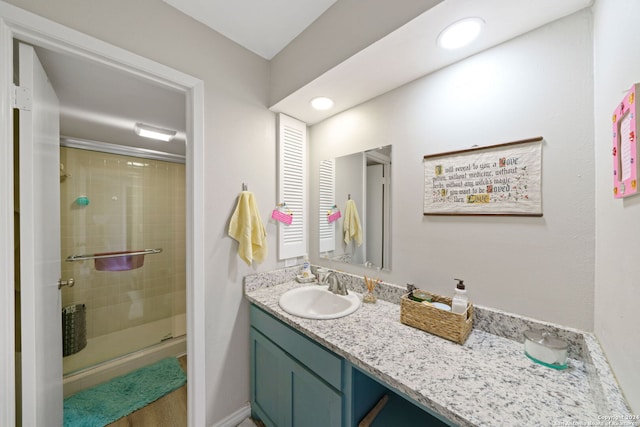 bathroom with an enclosed shower and vanity with extensive cabinet space