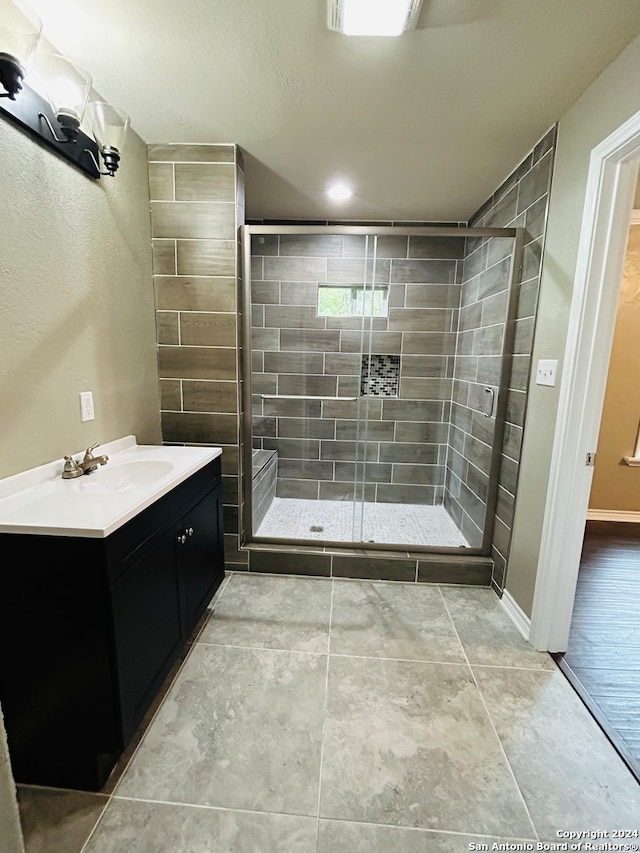 bathroom featuring tile floors, an enclosed shower, and vanity