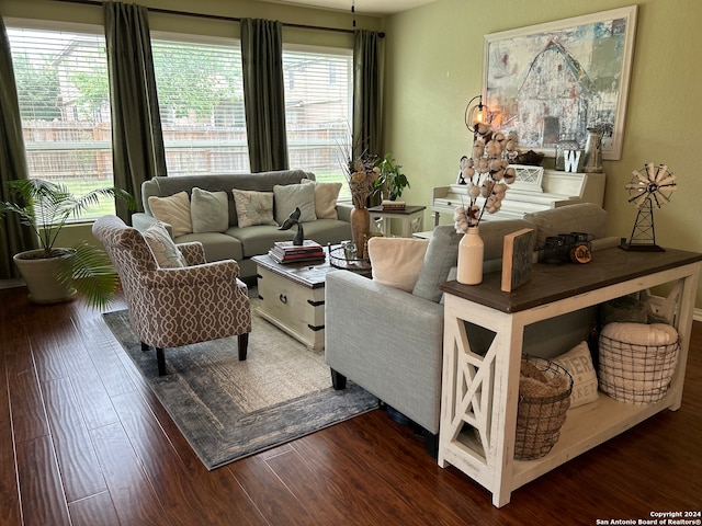 living room with dark wood-type flooring and a healthy amount of sunlight