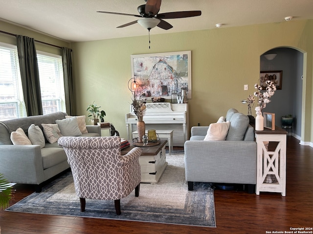 living room with ceiling fan, a textured ceiling, and dark hardwood / wood-style floors