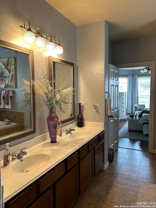 bathroom with double sink vanity, tile flooring, and a bathing tub