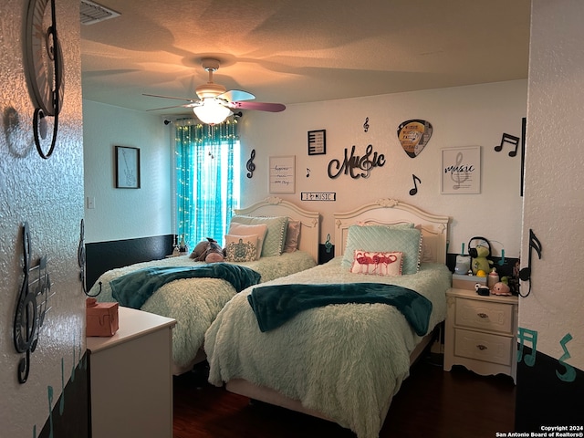 bedroom with dark hardwood / wood-style floors and ceiling fan