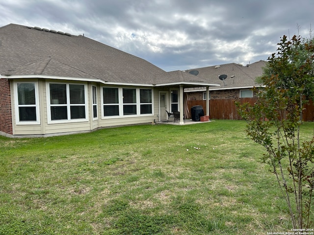 rear view of house with a patio area and a lawn