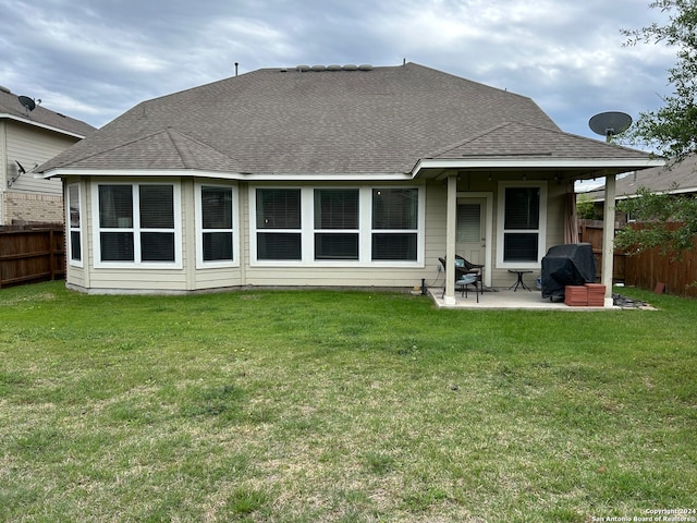 rear view of house featuring a yard and a patio