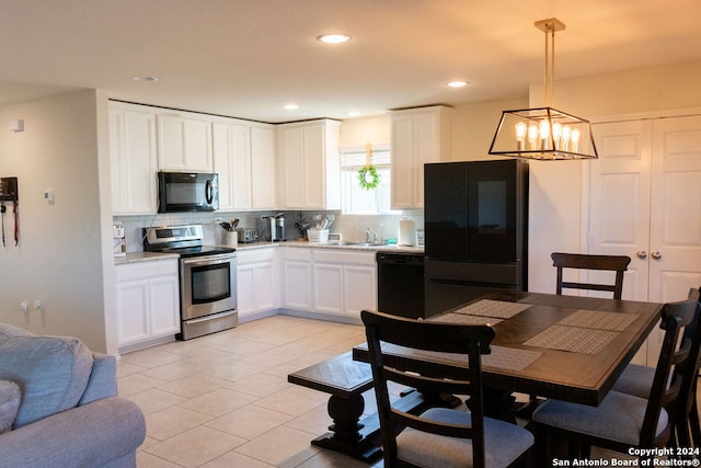 kitchen with a notable chandelier, decorative light fixtures, black appliances, white cabinetry, and backsplash