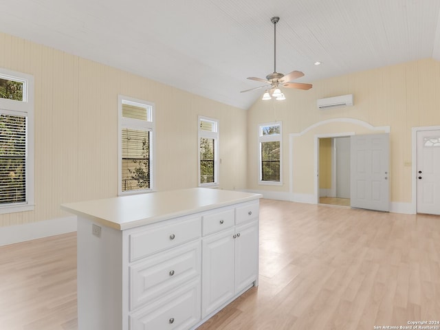 kitchen featuring lofted ceiling, a kitchen island, ceiling fan, light hardwood / wood-style flooring, and white cabinets