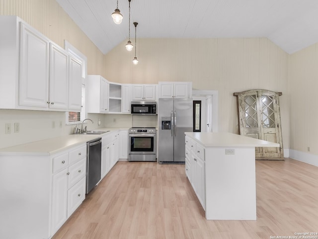 kitchen featuring light wood-type flooring, decorative light fixtures, appliances with stainless steel finishes, and white cabinetry