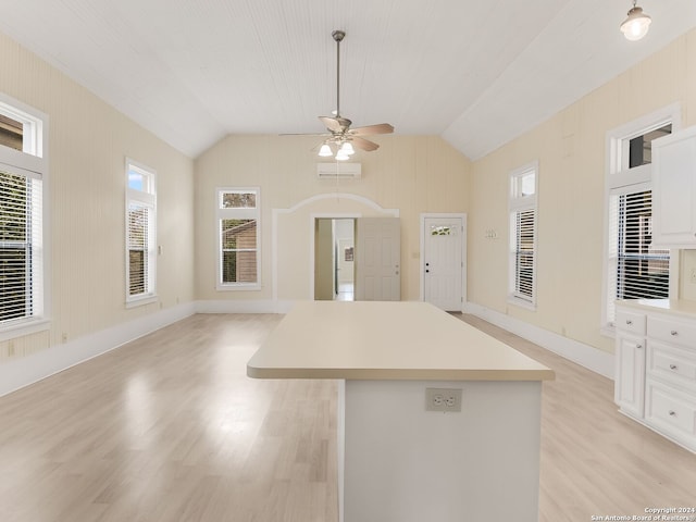 kitchen featuring vaulted ceiling, ceiling fan, white cabinetry, and light wood-type flooring