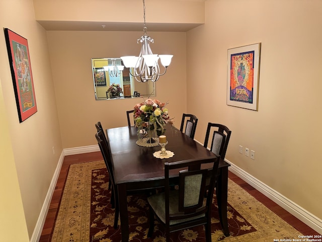 dining room with a notable chandelier and dark wood-type flooring