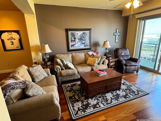 living room featuring dark wood-type flooring and ceiling fan