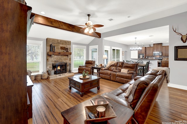 living room featuring a healthy amount of sunlight, hardwood / wood-style floors, ceiling fan with notable chandelier, and a fireplace