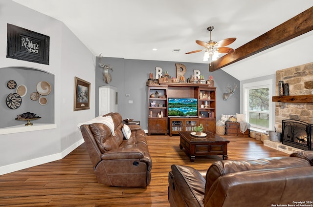 living room featuring a stone fireplace, ceiling fan, dark hardwood / wood-style floors, and lofted ceiling with beams