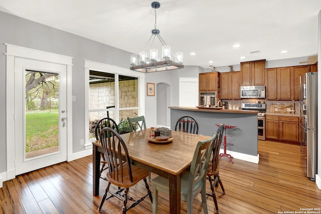 dining area featuring an inviting chandelier and light wood-type flooring