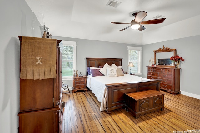 bedroom featuring light hardwood / wood-style floors, ceiling fan, and multiple windows