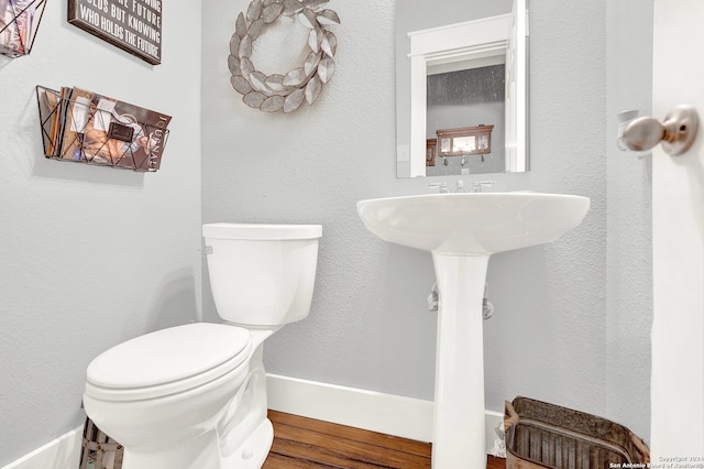 bathroom with hardwood / wood-style floors and toilet