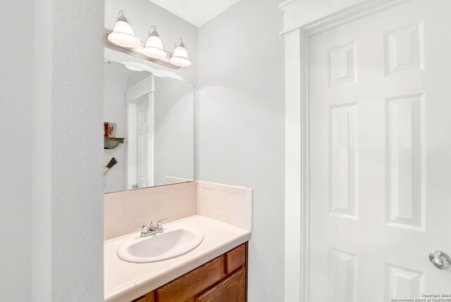 bathroom with vanity and tasteful backsplash