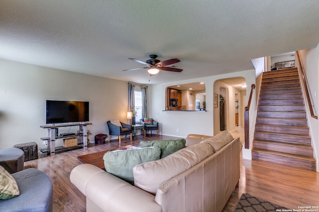 living room featuring a textured ceiling, ceiling fan, and hardwood / wood-style flooring