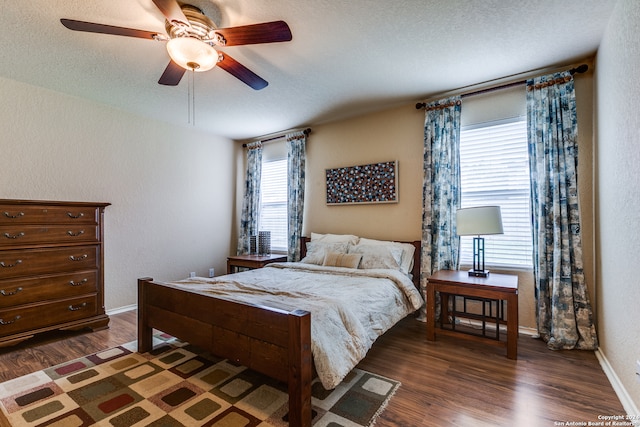 bedroom featuring dark hardwood / wood-style floors, a textured ceiling, and ceiling fan