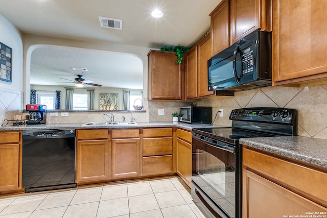 kitchen featuring light tile flooring, ceiling fan, black appliances, backsplash, and sink