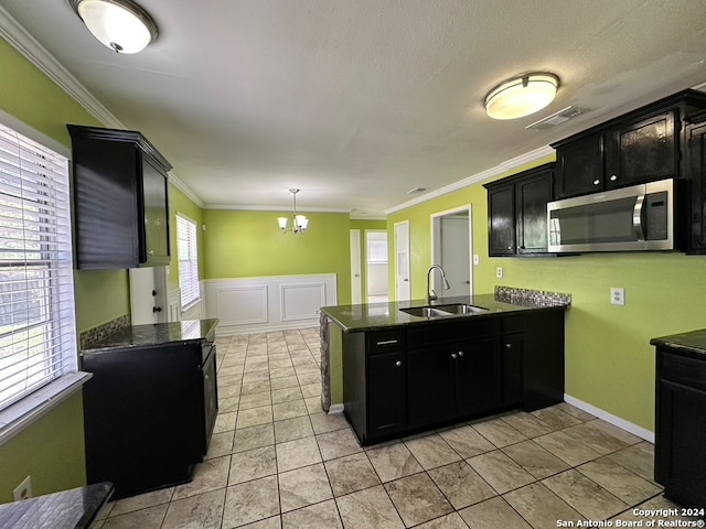 kitchen with crown molding, light tile floors, a notable chandelier, pendant lighting, and sink