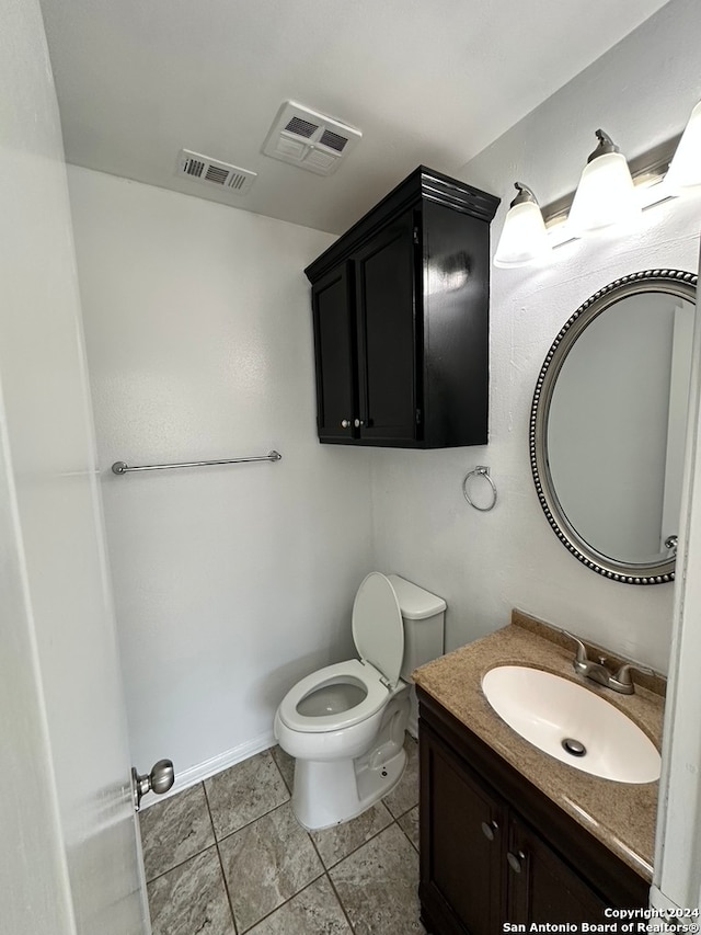 bathroom featuring vanity, toilet, and tile floors