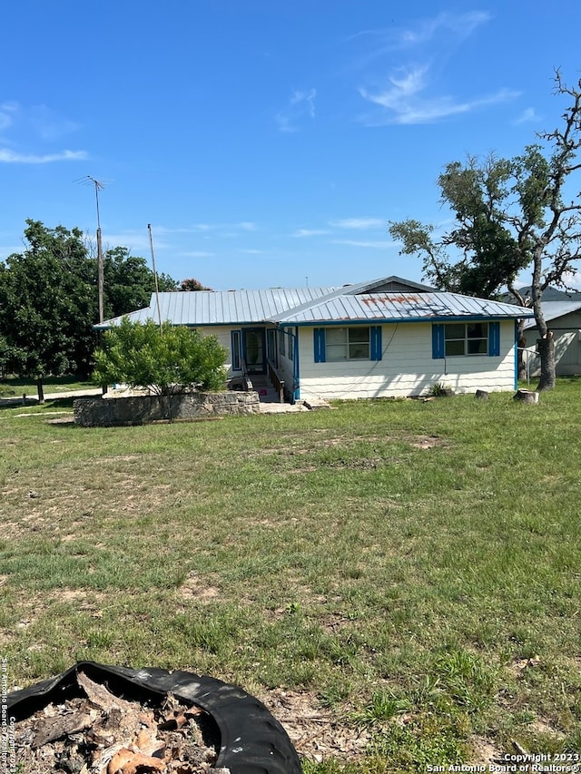 rear view of property featuring a yard