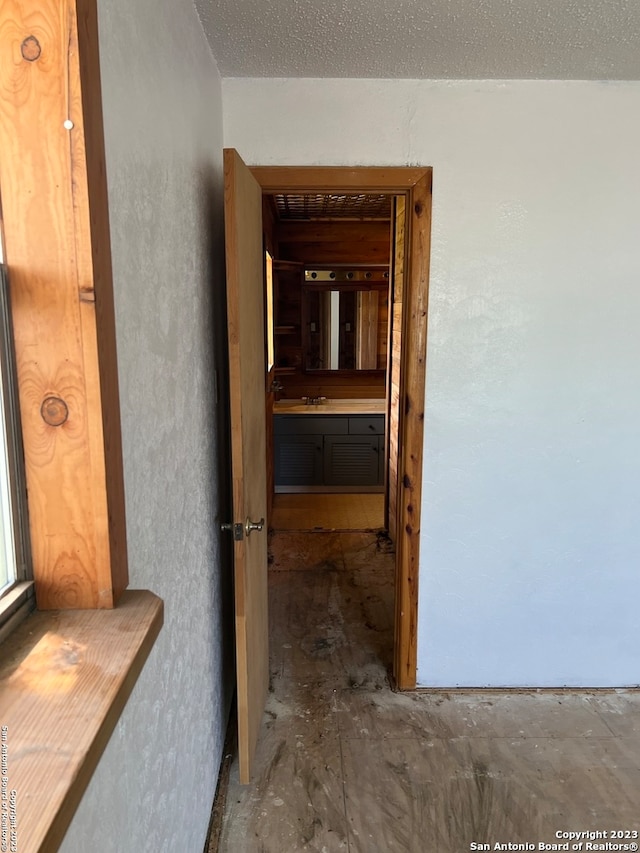 hallway with a textured ceiling and sink