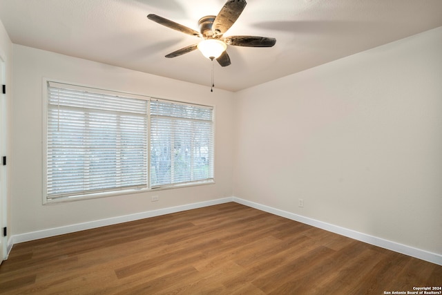 empty room with dark hardwood / wood-style flooring and ceiling fan