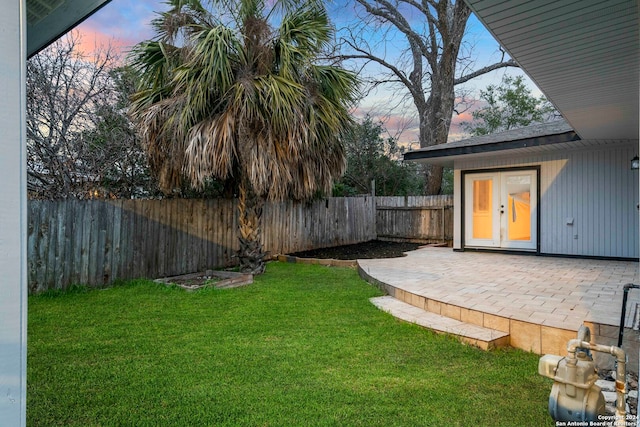 yard at dusk featuring a patio