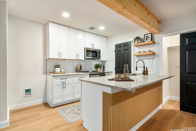 kitchen with light hardwood / wood-style flooring, stainless steel appliances, backsplash, and white cabinets