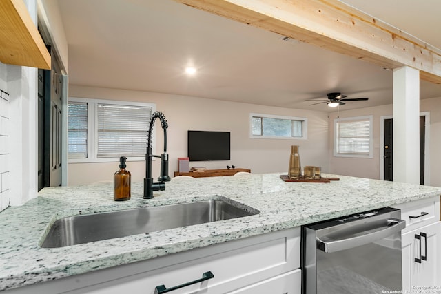 kitchen featuring stainless steel dishwasher, light stone counters, ceiling fan, sink, and white cabinetry