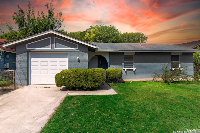 ranch-style home with a lawn and a garage