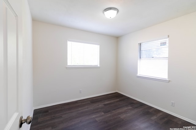 empty room with dark hardwood / wood-style flooring