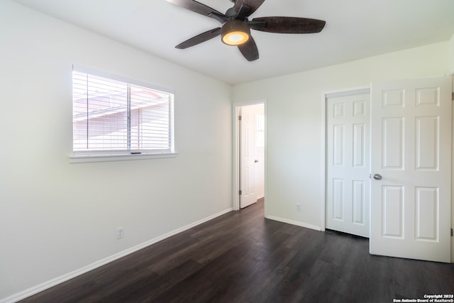 unfurnished bedroom featuring dark hardwood / wood-style floors, a closet, and ceiling fan