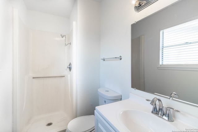 bathroom featuring vanity, toilet, and walk in shower