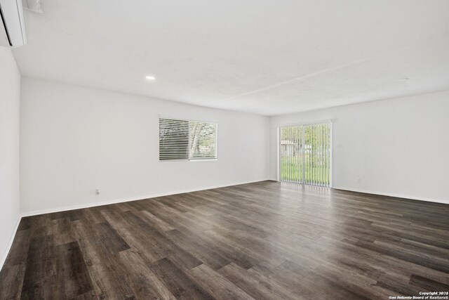 spare room featuring dark hardwood / wood-style floors and a wall mounted AC