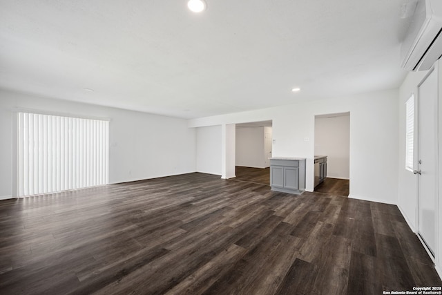 unfurnished bedroom with multiple windows, connected bathroom, and dark wood-type flooring