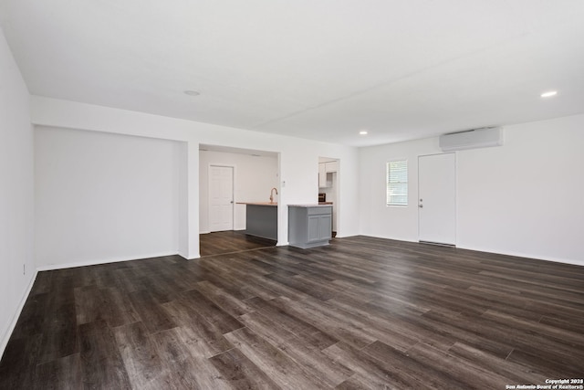 unfurnished living room featuring dark hardwood / wood-style floors and a wall mounted AC