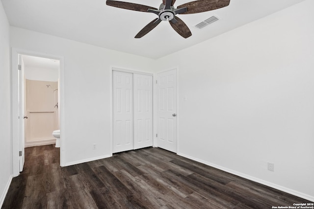 unfurnished bedroom with a closet, ensuite bath, dark hardwood / wood-style floors, and ceiling fan