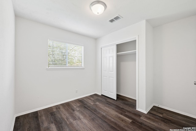 unfurnished bedroom featuring dark hardwood / wood-style floors and a closet