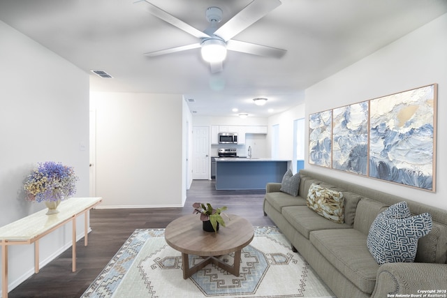 living room with ceiling fan, sink, and dark hardwood / wood-style flooring