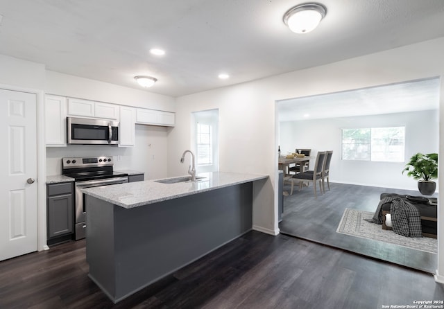 kitchen featuring sink, dark hardwood / wood-style flooring, appliances with stainless steel finishes, a wealth of natural light, and white cabinetry