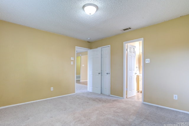 empty room featuring light carpet and a textured ceiling