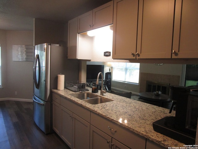 kitchen with stainless steel refrigerator, dark hardwood / wood-style flooring, sink, and light stone counters