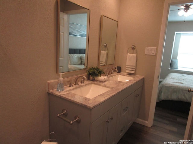 bathroom with double sink, oversized vanity, ceiling fan, and hardwood / wood-style flooring