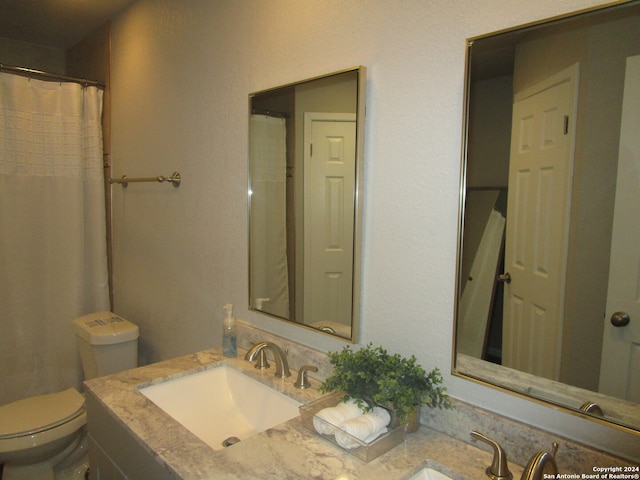 bathroom featuring vanity with extensive cabinet space and toilet