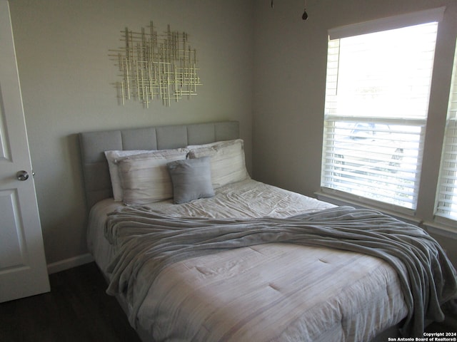 bedroom with dark wood-type flooring and multiple windows