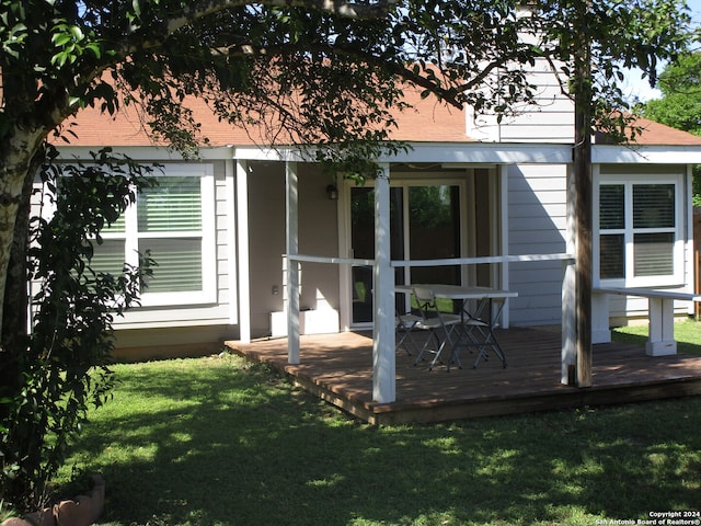 back of property with a wooden deck and a yard