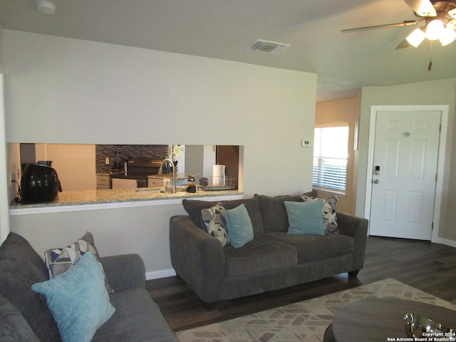 living room featuring ceiling fan, sink, and dark hardwood / wood-style flooring